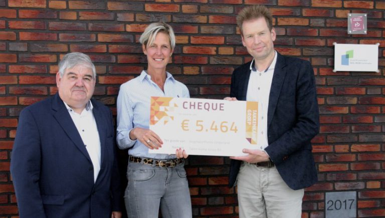 Mensen voor gebouw met cheque